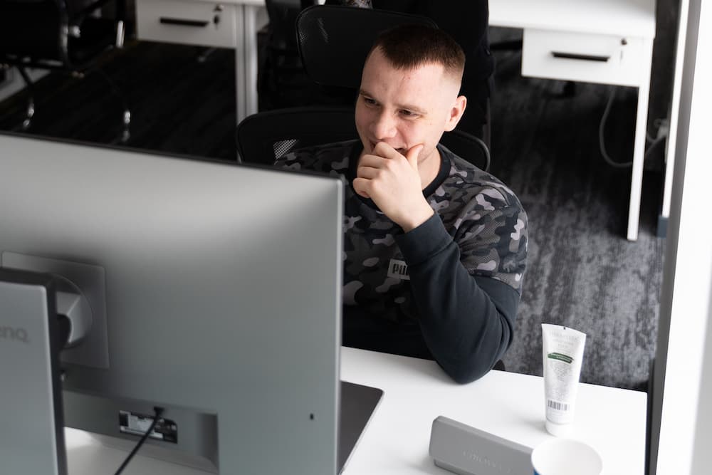 Serhii Shramko is sitting at a table with a computer